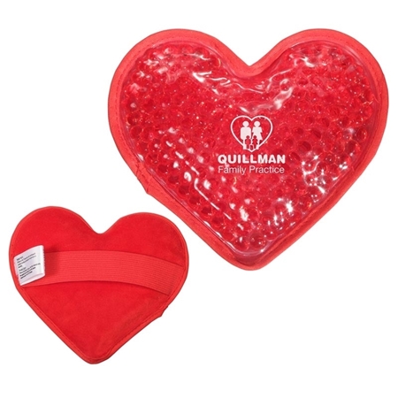 Red heart-shaped gel pack with text "Quillman Family Practice" and family icon. The back features a fabric cover with an elastic band and label.